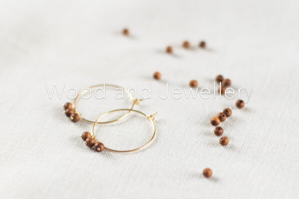 Image of golden creole earrings with sandalwood beads